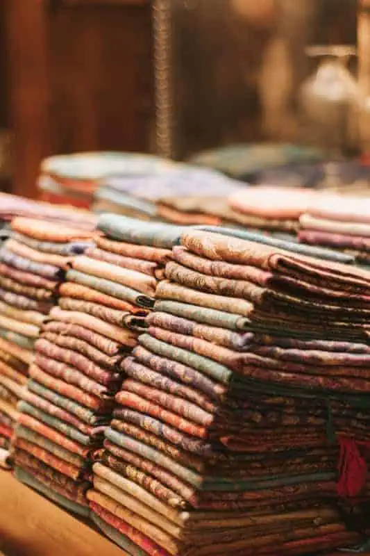 Vibrant quilt fabrics stacked in a craft room, perfect for quilting and sewing enthusiasts.