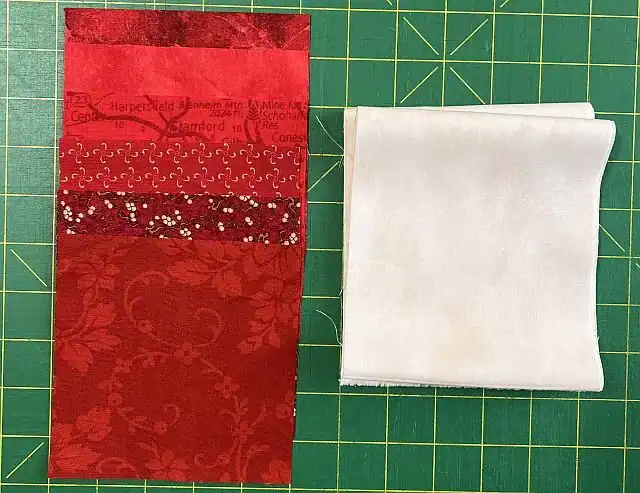 Colorful holiday quilt fabric with red hues and decorative patterns.