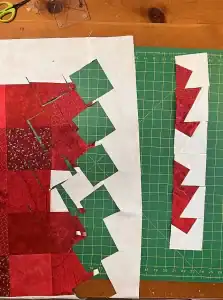 Alt text: Red and white quilt fabric pieces being sewn into a Christmas-themed quilt block.